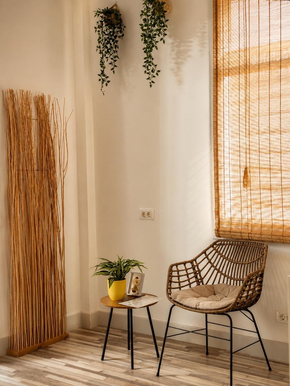 Zona de espera con silla de ratán, mesita y decoración de bambú